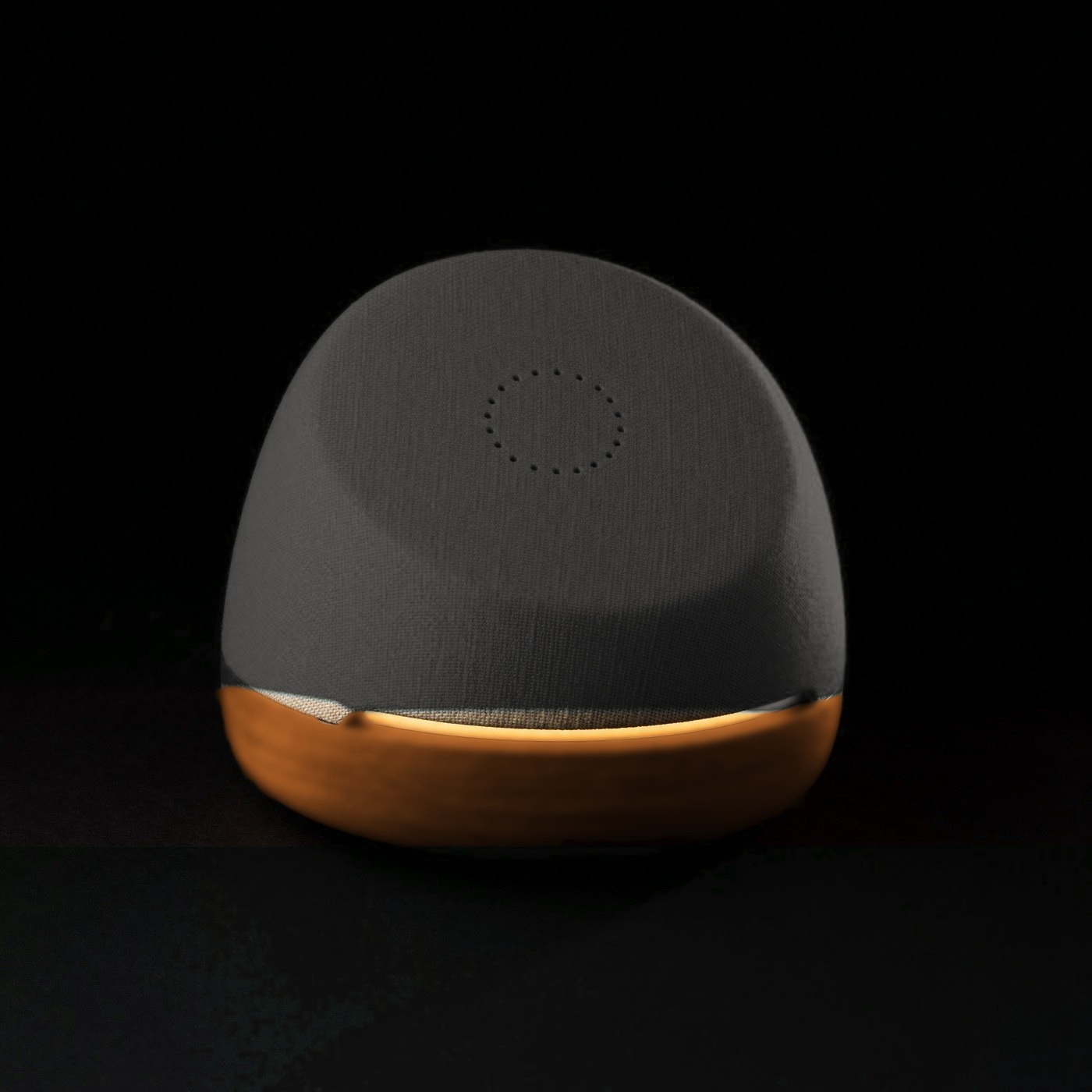 Hank concept: a soft tilted charcoal fabric dome on a warm tan base, its face turned toward the viewer, with a circle of microphone ports and a warm ochre light under the lip